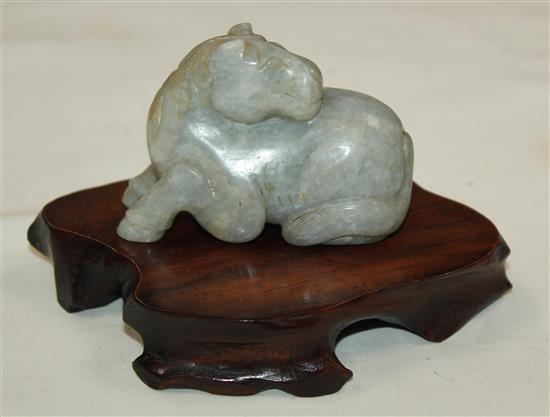 A Chinese mottled pale grey jade figure of a recumbent horse, probably Ming dynasty, 7.2cm, wood stand